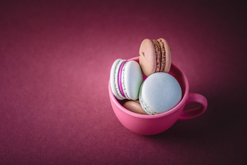 Obraz premium Selective focus of macarons field with cream in the cup. Copy space.