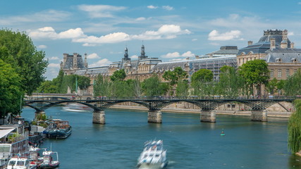 Touristic boat passes below Pont des Arts, on boat station on Seine river timelapse in Paris.