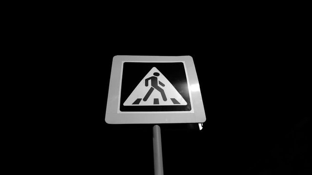 Pedestrian crossing sign. Traffic safety on the road. It's night outside.