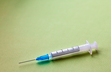 syringe closeup isolated on green background, copy space