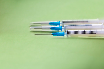 three syringes isolated on green background, copy space