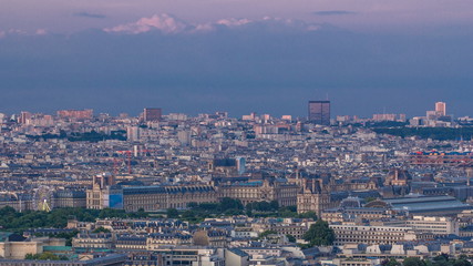 Obraz premium Aerial view of a large city skyline at sunset timelapse. Top view from the Eiffel tower. Paris, France.