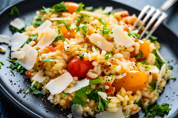 Risotto with parmesan on black stone background