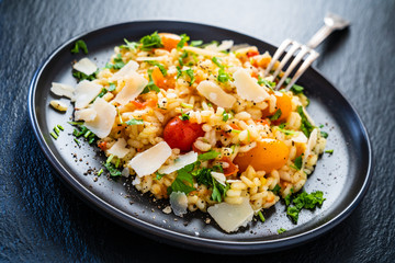 Risotto with parmesan on black stone background