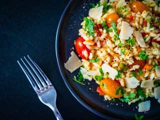 Risotto with parmesan on black stone background
