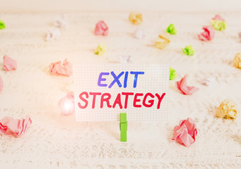 Conceptual hand writing showing Exit Strategy. Concept meaning Extricating oneself from a situation that is become difficult Green clothespin white wood background reminder office supply