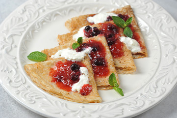 Thin pancakes with berry jam and cream.  Close-up.  Macro shot.  View from above.