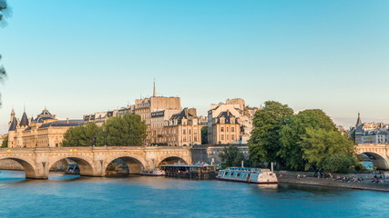 Fototapeta premium Sunset timelapse over Seine river, Pont Neuf bridge and Cite island with Royal palace, Conciergerie and medieval buildings. Paris, France