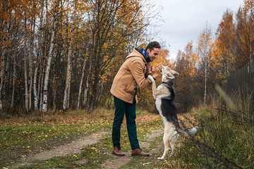 Cheerful guy communicating with dog in nature