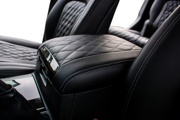 inter-seat armrest tucked in perforated leather and stitched in diamonds