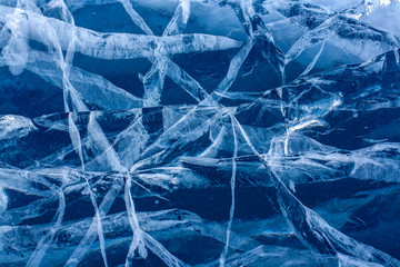 Cracked ice on Lake Baikal. Beautiful intersecting cracks in the ice. Horizontal.