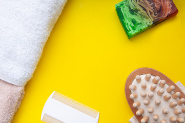 Bath accesories. Organic soap made from natiral ingredients. Comb and towel on a yellow background