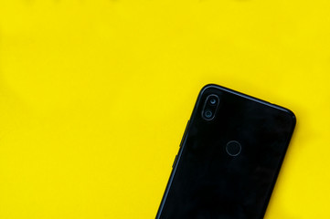 Black smartphone with toucj id on a yellow background