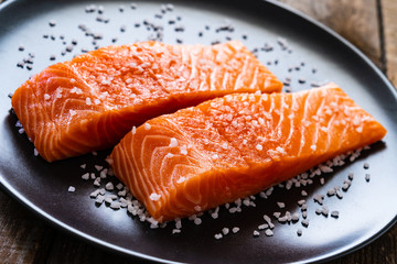 Fresh raw salmon steaks on wooden board