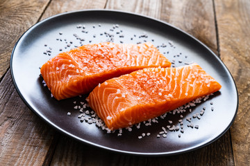 Fresh raw salmon steaks on wooden board