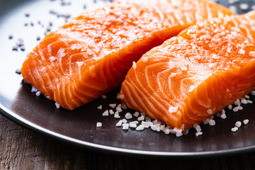Fresh raw salmon steaks on wooden board