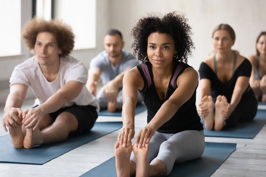 African woman and associates gather together for yoga training