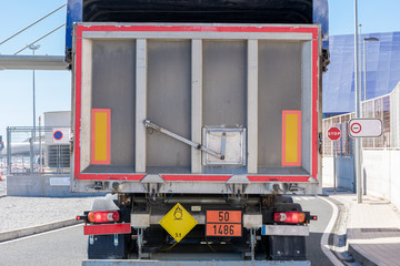 Rear view of a truck with dangerous goods plates with danger identification numbers, oxidizing solids, fertilizers.