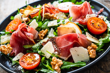 Tasty salad - ham and vegetables on wooden background