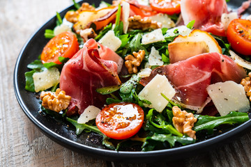Tasty salad - ham and vegetables on wooden background