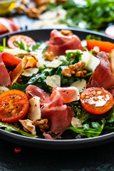 Tasty salad - ham and vegetables on black stone board
