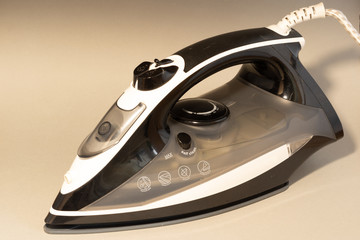 Modern electric iron against the plain background