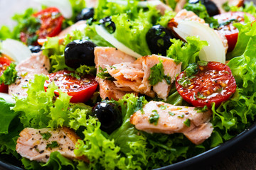Salmon salad - roasted salmon and vegetables on wooden background