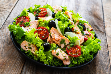 Salmon salad - roasted salmon and vegetables on wooden background