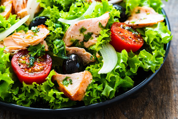 Salmon salad - roasted salmon and vegetables on wooden background