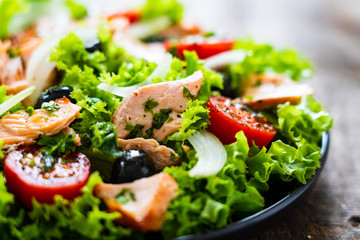 Salmon salad - roasted salmon and vegetables on wooden background