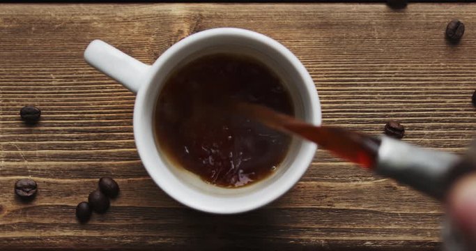 Top view of coffee pour into cup from big coffee maker
