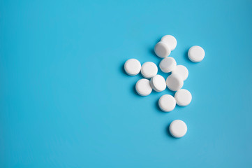 whte pills or tablets for virus on blue background