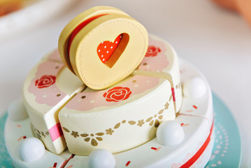 wooden festive three-tiered cake. toy made of pie pieces