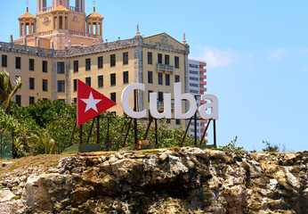 Cuba word sign with red triangle and a star over Hotel Nacional in Havana Cuba