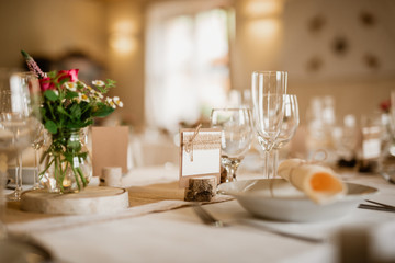 Detail of set table with name tag indicating a guest's place. Focused on empty nameplate decorated...