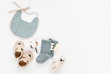 Bib,  socks, toy and cute baby slippers for boy.  Set of  newborn clothes and accessories. Flat lay, top view