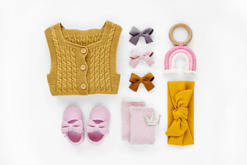 Yellow knitted romper,  socks and cute baby slippers.  Set of  newborn clothes and accessories. Flat lay, top view