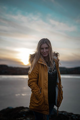 Fototapeta na wymiar Portrait of a smiling woman in her late twenties enjoying a short hike on a norwegian island on a dry winter weekend.