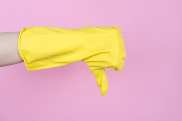 Cropped closeup side profile view photo of hand in yellow bright glove showing thumb down isolated...
