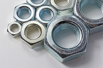 New chrome screw-nut of different sizes on a white background. Concept.