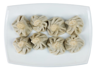 Boiled khinkalis (Georgian dumpling) on a white plate