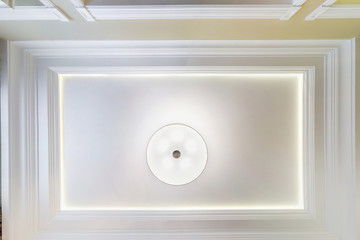 looking up on suspended ceiling with halogen spots lamps and drywall construction in empty room in apartment or house. Stretch ceiling white and complex shape. © hiv360