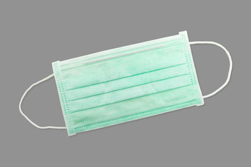 New green 3 ply disposable surgical mask isolated on gray background, with clipping path