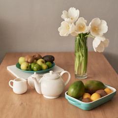 Beautiful tea service on wooden table. Home interior decor, bouquet of flowers in vase, table with set of teapot. Good morning concept. English breakfast. Breakfast at hotel room. Copy space