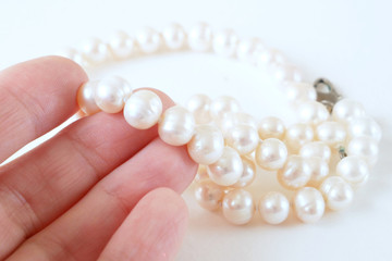 jeweler take in hand the pearl necklace, jewerly inspect and verify