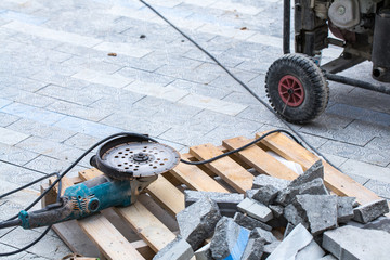 Construction work on pavement. Installation of concrete paver blocks on the sidewalk. Disc cutter...