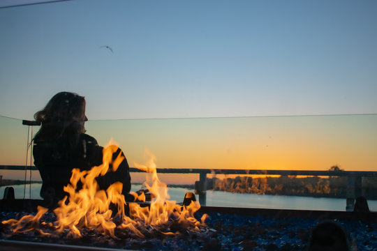 Young Woman Enjoying Sunset In Marina Del Rey In Winter With Fire Pit