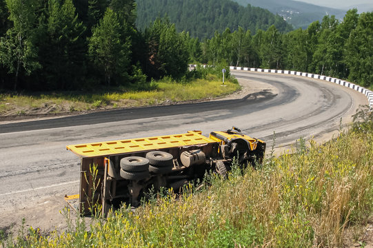 Road Accident A Dump Truck Didn't Fit Into Sharp Turn. An Overturned Truck On An Highway In An Accident. Crashed Dump Truck On A Road.