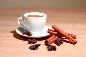 A cup of coffee with heart pattern in a white cup on wooden background