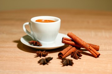 A cup of coffee with heart pattern in a white cup on wooden background